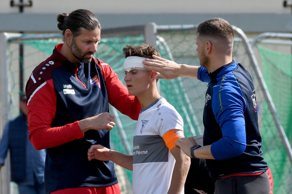 Manuel Linke (l.) und Chris Thannheiser verarzteten die Platzwunde, sodass Kapitän Yannick Lachowicz weiterspielen konnte. Foto: MSW